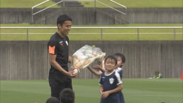 指導した子供たちから花束を受け取る長谷部選手　2022年6月