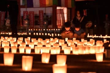 東日本大震災十三回忌追悼法要で、ろうそくが並ぶ潮音寺の境内=潮来市日の出