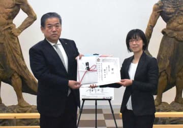 大塚秀喜市長(左)から表彰を受けた最優秀賞の藤本希さん=桜川市本木