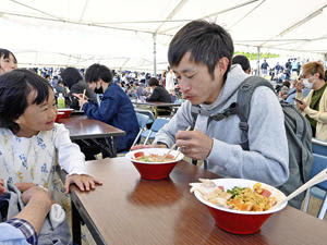 福島ラーメン組獅子奮迅隊のシン・フクシマ鶏白湯を食べる来場者