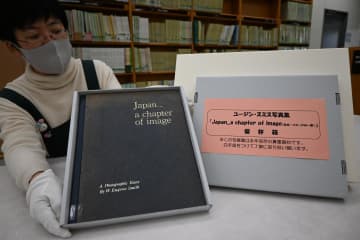 日立市立記念図書館が所蔵するユージン・スミス写真集(左)と専用の保存箱=日立市幸町