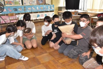 実際に発掘調査で見つかった土器などに触れる児童たち=常陸太田市真弓町