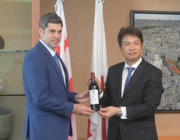 大井川和彦知事(右)にジョージア産ワインを贈るティムラズ・レジャバ駐日大使=県庁