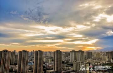 トルファンの火焰山の地表温度が80度以上を記録した。写真は18日早朝、雲が広がったウルムチ市の空。