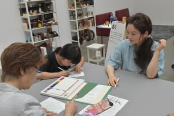 塗り絵のワークショップの参加者に寄り添う曽谷朝絵さん(右)=水戸芸術館現代美術ギャラリー