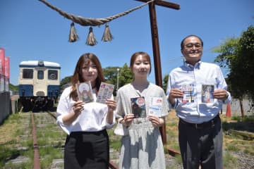 ひたちなか開運鐵道神社前で駅印を披露する佐藤久彰三鉄ものがたり実行委員会代表と、駅印を制作した坂本いおなさん、大内れなさん(右から)=ひたちなか市阿字ケ浦町