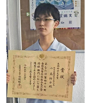 将棋部門で優勝し、賞状を手に喜ぶ小島さん