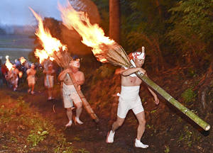 たいまつの火の粉を散らしながら山頂を目指した「麓山の火祭り」＝15日午後6時35分、富岡町