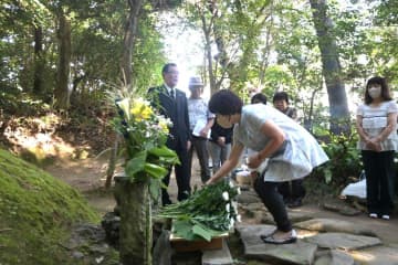 岡倉天心の墓前に献花する顕彰会の会員たち=北茨城市大津町五浦