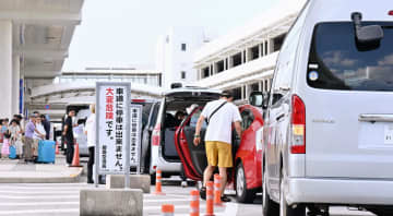 県レンタカー協会に非加盟の中小業者が利用する送迎スペース。多くの業者の車列が走行車線まで続いていた＝8月18日、那覇空港