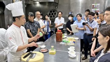 黒糖を使った中華料理を紹介するシェフ（左端）＝13日、東京・渋谷