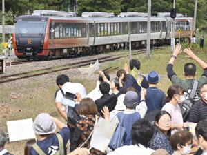 JR只見線の全線再開1周年を記念し、只見駅を出発する記念列車「海里」を見送る町民ら＝1日午後1時5分、只見町