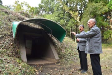 虎塚古墳の石室に続く扉の前で当時を振り返る川崎純徳さん、鴨志田篤二さん(右から)=ひたちなか市中根