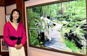 現在制作中の滝川渓谷をテーマにした油彩画の横に立つ山本さん。「日常の何げない風景を描き続けたい」と話す