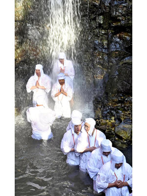 冷たい滝に打たれながら、一心不乱に祈りをささげる参加者