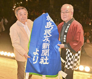 中川社長（左）からのぼり旗を受ける星座長