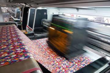 浙江省紹興市柯橋区の印刷・染色企業をこのほど取材したところ、作業員がデジタルプリント生産ラインで急ピッチで作業を進めていた。