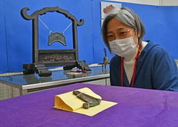 せんまや街角資料館の企画展「磐井の中世を探る」で公開されている仏具の磬の破片（奥州市衣川出土）。参考品（奥）のようにつるして音を鳴らした