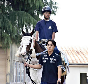 仲間を担う薄井さん（手前）と馬上の伊東さん。野馬追の開催はテスト期間中だが「貴重な機会だから力になりたい」と意気込む＝相馬農高