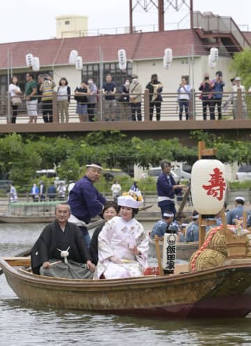 潮来あやめまつり期間中に運行される、恒例の嫁入り舟に乗る新婦の飯田典美さんと新婦の両親=潮来市あやめ