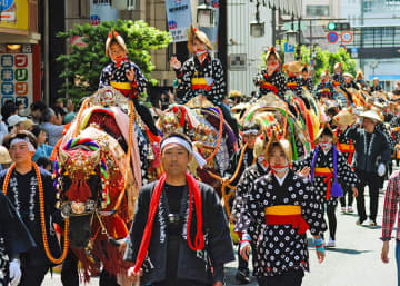 馬コのパレードで、馬上から見物客に手を振る乗り手たち＝盛岡市大通