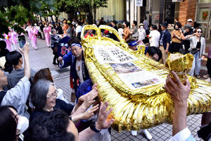 東北絆まつりの躍り流しで披露された福島わらじまつりの金わらじ。訪れた大勢の観客が手を伸ばした