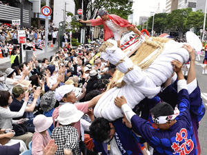 「東北絆まつり」のパレードで披露された大わらじ。沿道に大きく傾くと観客から歓声が上がった＝9日、仙台市