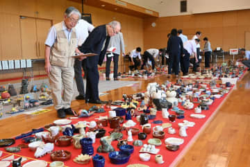 個性豊かな陶芸作品が並ぶ中、入賞作品を選ぶ審査員=笠間市箱田