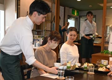 心を込めて作った料理を提供する学生（左）