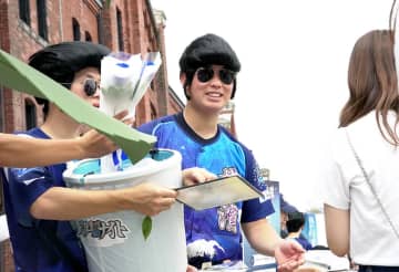 横浜のまちで青バラなどを配るスターナイト隊（球団提供）