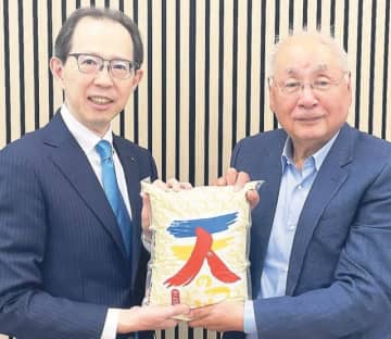 福島県産米「天のつぶ」を手にする河本社長（右）と内堀知事（英ロンドンで＝福島県提供）