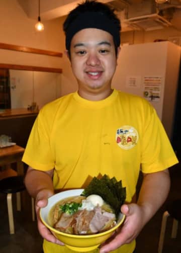 特製濃厚鶏塩ラーメンをアピールする伊勢野匠店長。クリーム色のスープは鶏のうまみが溶け込む