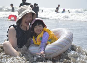 海開きした大洗サンビーチ海水浴場で水遊びを楽しむ親子=大洗町大貫町