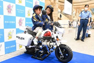 昨年の「ふれあい警察展」で制服を着て白バイ乗車体験をする子ども＝2023年7月、横浜市港北区のトレッサ横浜