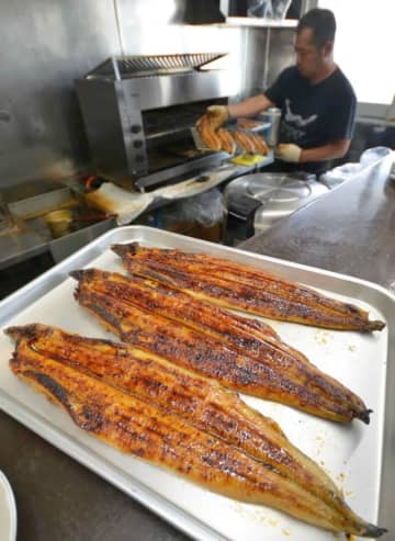 土用の丑の日に向けて焼かれるウナギ=23日、田原本町味間の鰻福