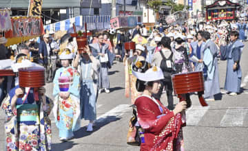 行器を持ち、花嫁衣装の女性らが練り歩いた七行器行列＝23日午前、南会津町田島