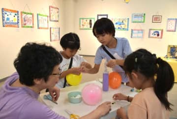 ワークショップで風船にシールを貼る子どもたち=水戸市赤塚