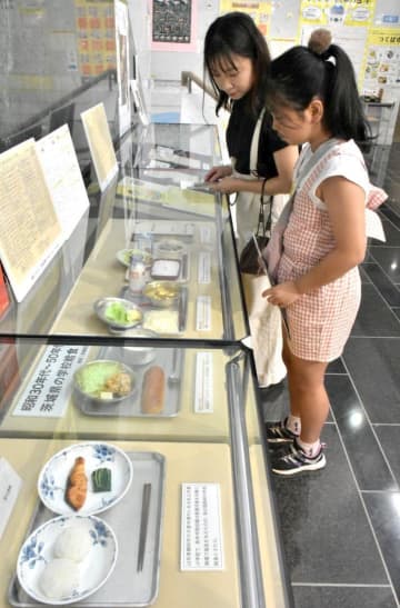 学校給食のレプリカの展示を見る来館者=つくば市上沢