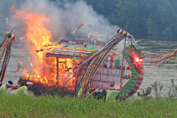 花火や爆竹を鳴らしながら赤々と燃え上がる舟