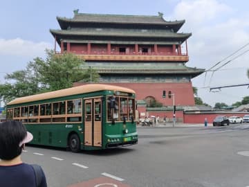 8月17日午前、北京市の前門大街の街角では、「カランカラン」という音が聞こえると、観光客がやって来たレトロなバスに順序よく乗り込んでいた。