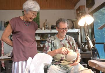 作品を手にする陶芸家のローランドサクセさん(右)と妻のひろ子さん=桜川市門毛