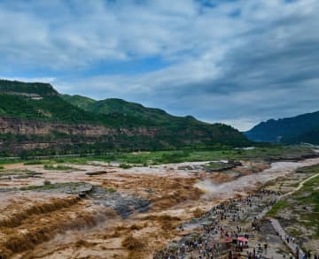 上流で雨が降った影響で、黄河の壺口瀑布は26日、滝の主流と支流が一つの大きな流れに変わっていた。