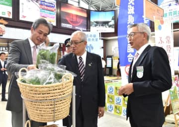 エキナカマルシェで常陸大宮市の有機野菜を手にする鈴木定幸市長(左)ら=JR水戸駅