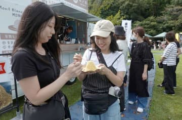 かさま新栗まつりの会場でモンブランを購入し笑顔を見せる来場者=笠間市笠間