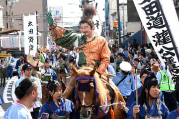 太田道灌役を務め、馬上から声援に応える小田井さん（中央）＝6日、伊勢原市内