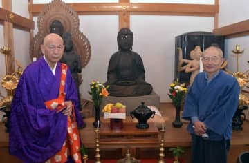 仏師の小松崎卓さん(右)によって修復された阿弥陀如来座像。左は黒沢彰哉住職=かすみがうら市下志筑