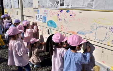 水族館の思い出をバスの車体に描く園児たち=常陸太田市谷河原町