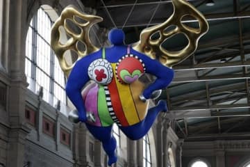 チューリヒへようこそ！ニキ・ド・サンファルの「守護天使」が、チューリヒ中央駅を行き交う通勤客を見守る (Keystone/eddy Risch)