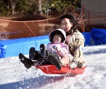 「雪・そり遊び広場」がオープンし、雪遊びを楽しむ親子＝箱根町元箱根の箱根園